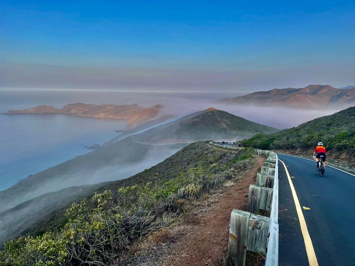 Cyclists riding through the winding roads of the Marin Headlands with ocean views